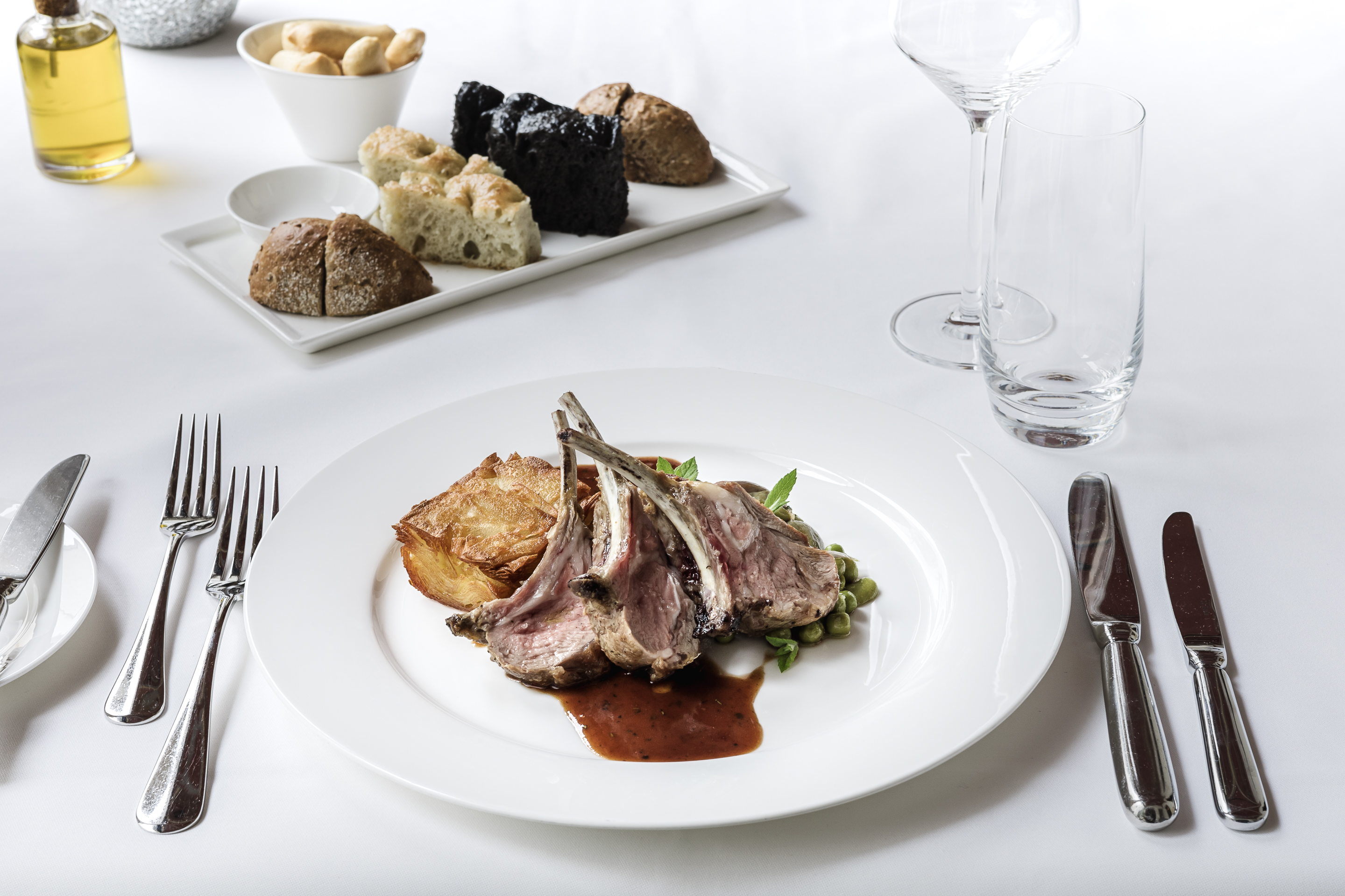 Piatto di carne impiattato con cura su un tavolo elegante, fotografato da Stylio